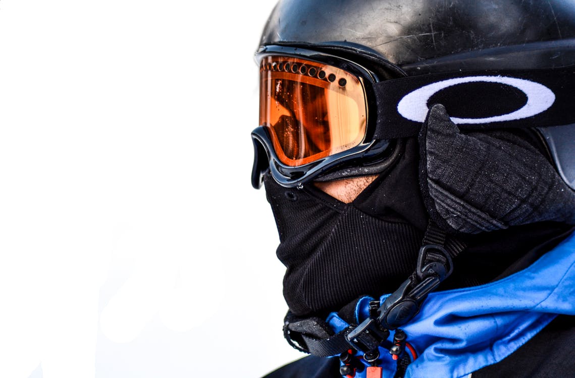 Cerca de las gafas de esquí de un hombre con el reflejo de las montañas  nevadas